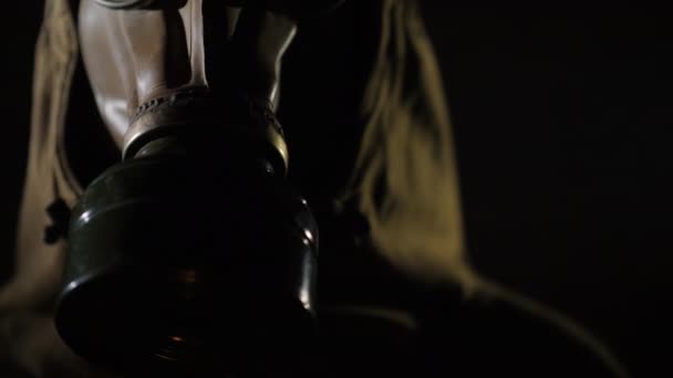 Портативный снимок человека в защитном костюме и противогазе, дым на переднем плане — стоковое видео