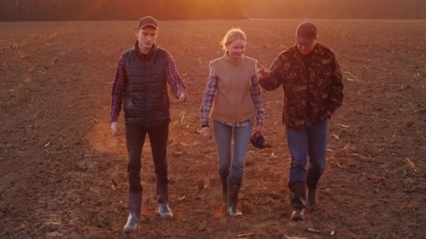 Μια επιτυχημένη οικογένεια αγροτών πηγαίνει σε οργωμένο χωράφι.. — Αρχείο Βίντεο