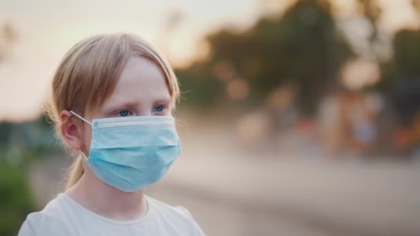 Une fille dans un bandage de gaze se tient près d'une route poussiéreuse. Problèmes de concept environnemental — Video