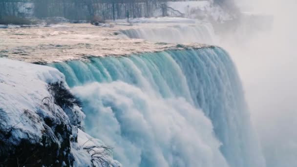 Niagara Falls en hiver. Ruisseaux d'eau entourés de rivages enneigés .