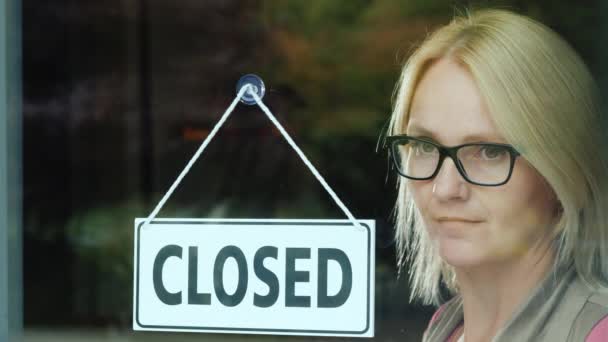 Masadaki üzgün bir kadının portresi kapıya kapatıldı. İşletme konsepti kapanıyor — Stok video