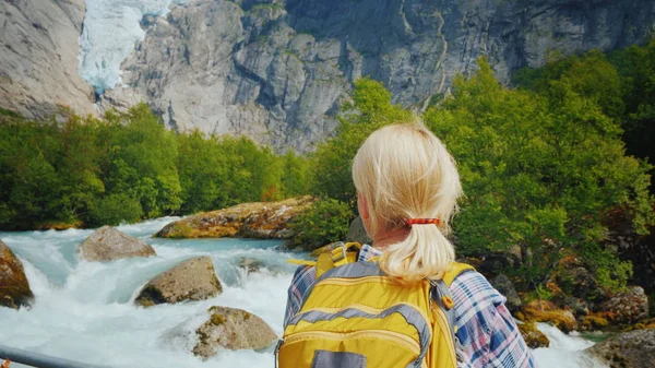 Active woman on a trip to Norway. Enjoys the beautiful Briksdal Glacier — Stock Photo, Image