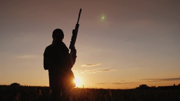 Una atleta con un arma mira hacia el atardecer. Concepto de tiro deportivo para mujer — Vídeos de Stock