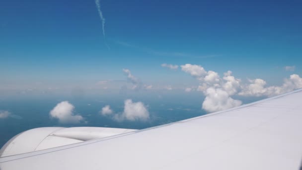 Utsikt från flygplanets fönster på flygplanets vinge med en stor motor och vackra moln — Stockvideo