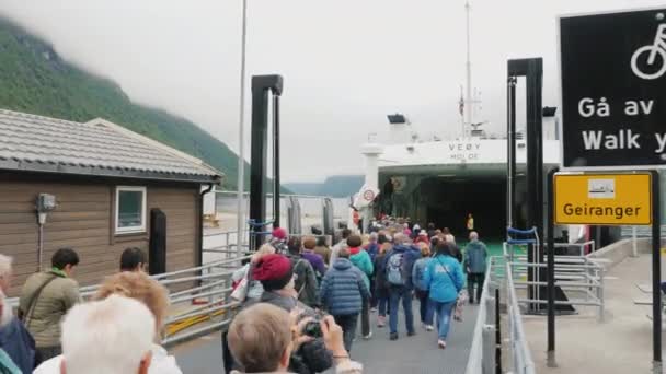 Flam, Noruega, julio de 2018: Autobuses, coches y turistas salen del ferry a la orilla del fiordo. Un grupo de otras personas y el transporte se están preparando para abordar — Vídeos de Stock