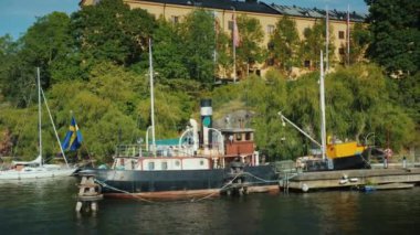 Stockholm apartmanının arka planında kıyıya demirlemiş eski bir mavna.