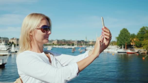 Ein tourist wird auf einer brücke mit blick auf stockholm, schweden fotografiert — Stockvideo