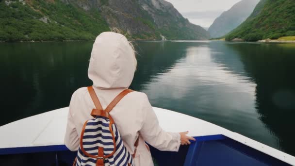 フードショップの女性が船の船首に立っている。ノルウェーの概念のフィヨルドクルーズ — ストック動画