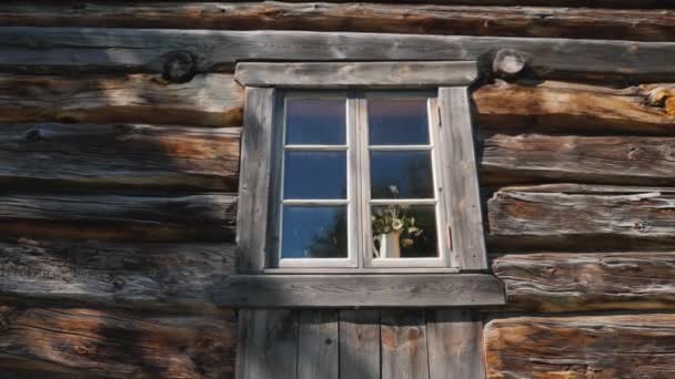 Ventana sobre una antigua casa de madera hecha de troncos — Vídeo de stock