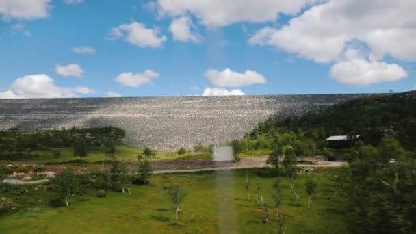 Uitzicht vanuit een autoraam op een landschap in Noorwegen met een grote stenen dam — Stockvideo