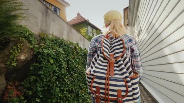 ノルウェーのベルゲンの狭い通りを歩く彼女の手に地図を持つ観光客。スカンジナビアの祝日 — ストック動画