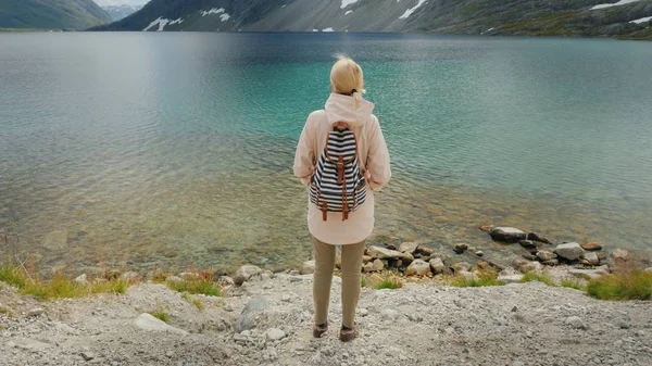 Женщина восхищается красивым высокогорным озером в горах Норвегии. Крановый выстрел — стоковое фото