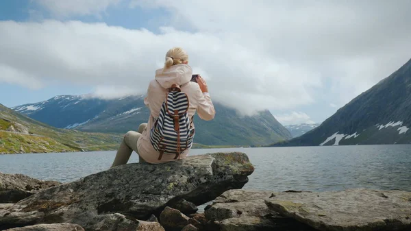 Путешественник фотографирует живописное высокогорное озеро в Норвегии — стоковое фото