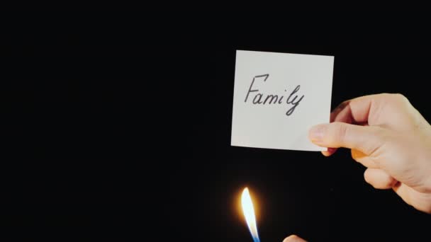 Homem queima papel com a inscrição Família — Vídeo de Stock