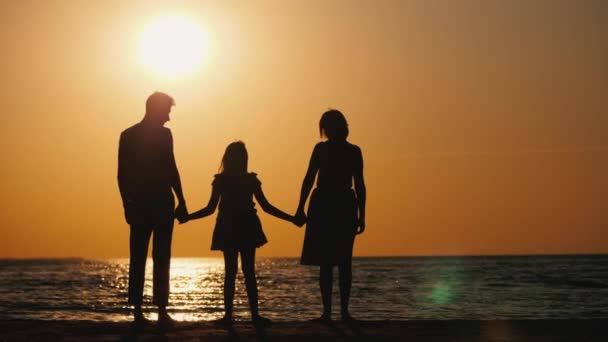 En familj med ett barn sträcker upp sina händer vid solnedgången. Vänliga friska sei ett begrepp — Stockvideo