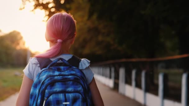 Κορίτσι με σχολική τσάντα πηγαίνει σχολείο το πρωί. Βίντεο με ρηχό βάθος πεδίου — Αρχείο Βίντεο