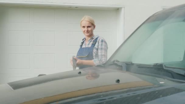 Woman in overalls my black SUV — Stockvideo