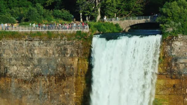 新娘的瀑布般的面纱和游客在它上面漫步。 美国和加拿大边境著名的尼亚加拉瀑布 — 图库视频影像
