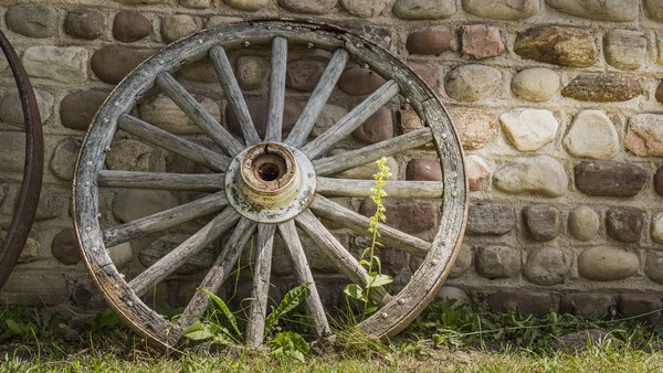 Oude radslag bij de stenen muur van een oud gebouw — Stockfoto