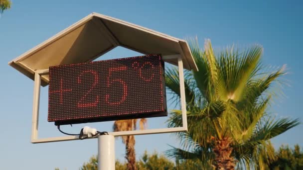 Volgens het scorebord op het strand is het 25 graden Celsius. — Stockvideo