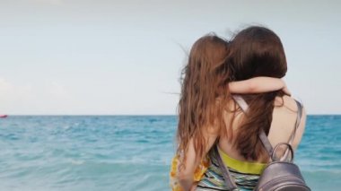 İki kişilik bir aile sahilde oturuyor ve deniz manzarasının tadını çıkarıyor. Arka plan