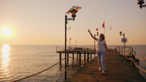 Kobieta z latawcem biegnie na molo — Wideo stockowe