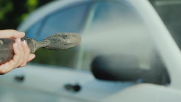 Tvätta bilen med en högtryckstvätt, munstycket där vatten läcker syns i ramen — Stockvideo