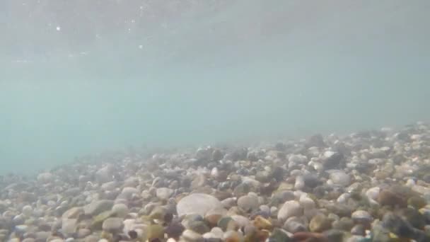 Les pierres de mer de différentes tailles se balancent avec le surf dans différentes directions. Tournage sous-marin — Video