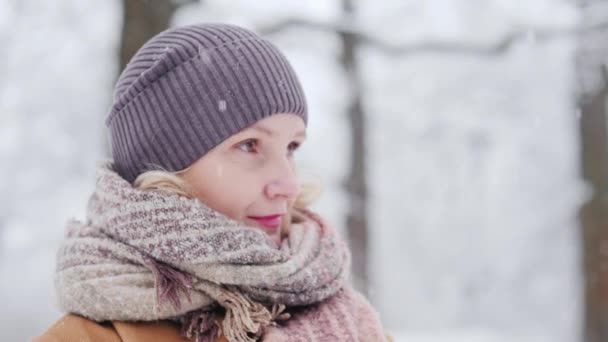 Side view of a middle-aged woman in a winter park — Stockvideo