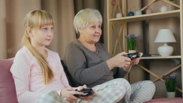 Mujer anciana activa juega con su nieta en videojuegos — Vídeo de stock