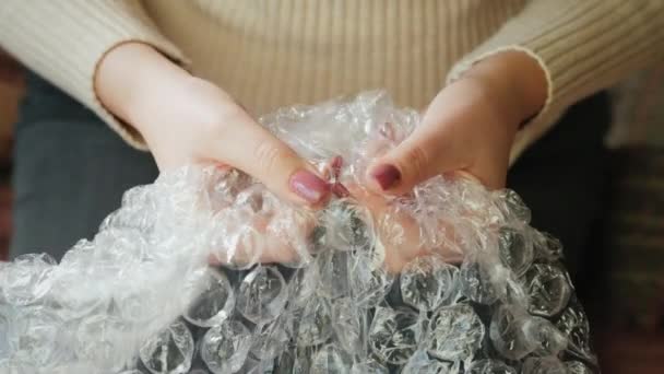 Vista dall'alto di Una donna scoppia bolle d'aria su un film di avvolgimento. Concetto di riduzione dello stress — Video Stock