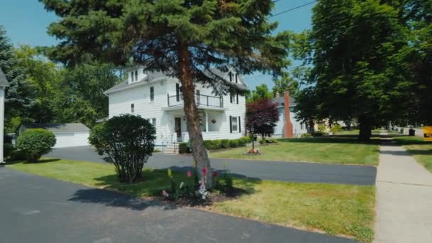 Walk along the sidewalk in a typical American neighborhood, along white wooden houses and mowed lawns — Stock Footage Walk along the sidewalk in a typical American neighborhood, along white wooden houses and mowed lawns Stock Video