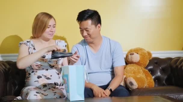 A young couple received a parcel with things for their future baby — Stock Video