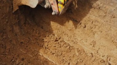 Güçlü kazıcı kovası çukurdan zemin çıkarıyor. İnşaat alanında iletişim kurmak.