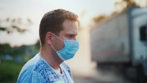 Человек в защитной маске на пыльной дороге. Концепция экологических проблем — стоковое видео