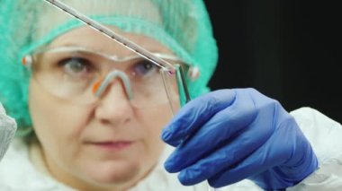 Kadın araştırmacı laboratuarda ilaçlarla çalışıyor, yeni ilaçlar geliştiriyor.
