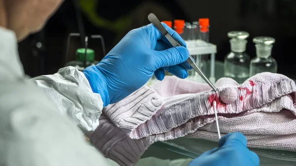 Médico legista remove sangue em roupas, investigação criminal — Fotografia de Stock
