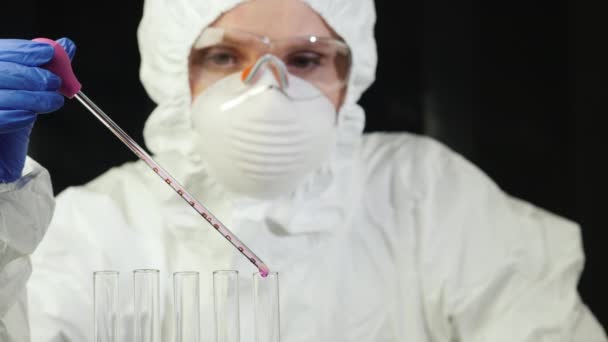 Un hombre con traje de protección biológica trabaja en un laboratorio. — Vídeo de stock