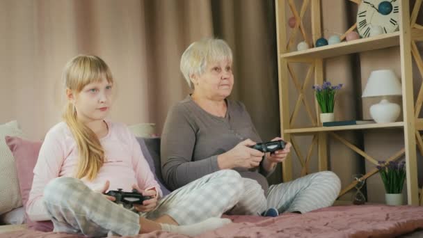 Fille et grand-mère s'amusent ensemble, jouer à des jeux vidéo — Video