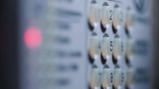 Close-up shot van een persoon voert een pincode in op een verlicht toetsenbord — Stockvideo