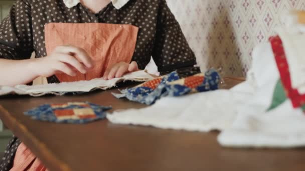 Una mujer en un vestido antiguo de la época del desarrollo de América se dedica a la costura — Vídeo de stock