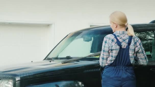 Visão traseira da mulher de macacão meu SUV preto — Vídeo de Stock