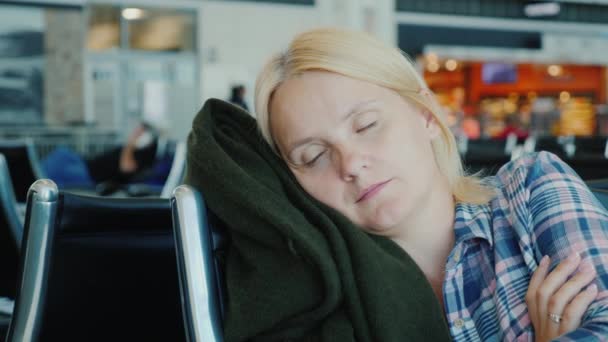 Una donna dorme in un terminal dell'aeroporto. Concetto ritardo del volo — Video Stock