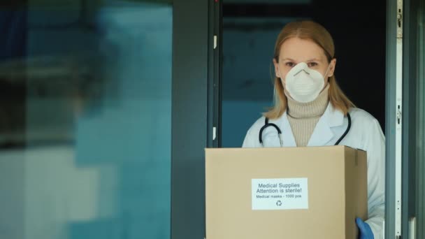 Retrato de um médico com uma caixa de máscaras médicas protetoras. — Vídeo de Stock