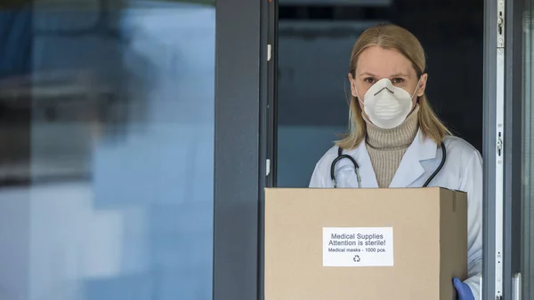 Portret lekarza z pudełkiem ochronnych masek medycznych. — Zdjęcie stockowe