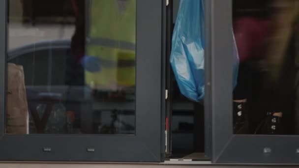 Voluntario recoge una bolsa de basura en la puerta de la casa donde la gente está en auto-aislamiento — Vídeos de Stock