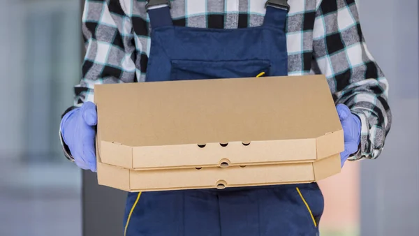 피자 의안 전하게 배달되는 배달인 은 보호 장갑으로 상자를 들고 있다. — 스톡 사진