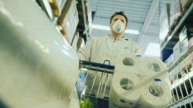 Salgın sırasında mallara olan talep artışı. Bir adam tramvayda tuvalet kağıdı ve erzak taşır.