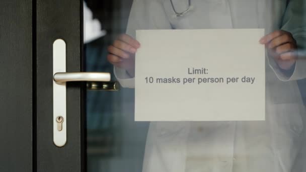 Announcement on the pharmacy door about the limit of sales of medical masks — Stock Video