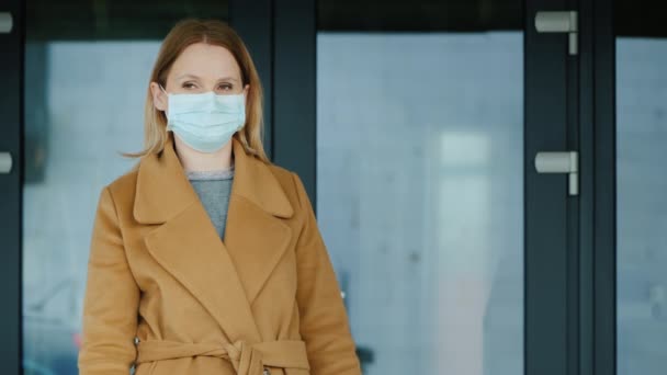 Kobieta w rękawiczkach i maskach z torbami zakupów na tle wejścia do sklepu spożywczego — Wideo stockowe